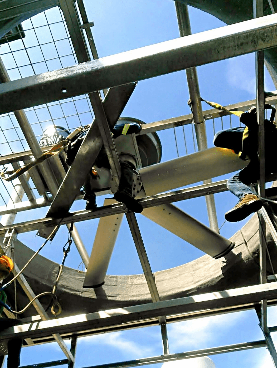 Technicians working beneath cooling tower equipment