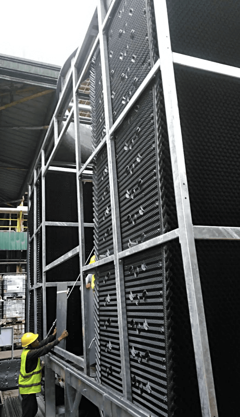 Technician installing cooling tower fill and structural components